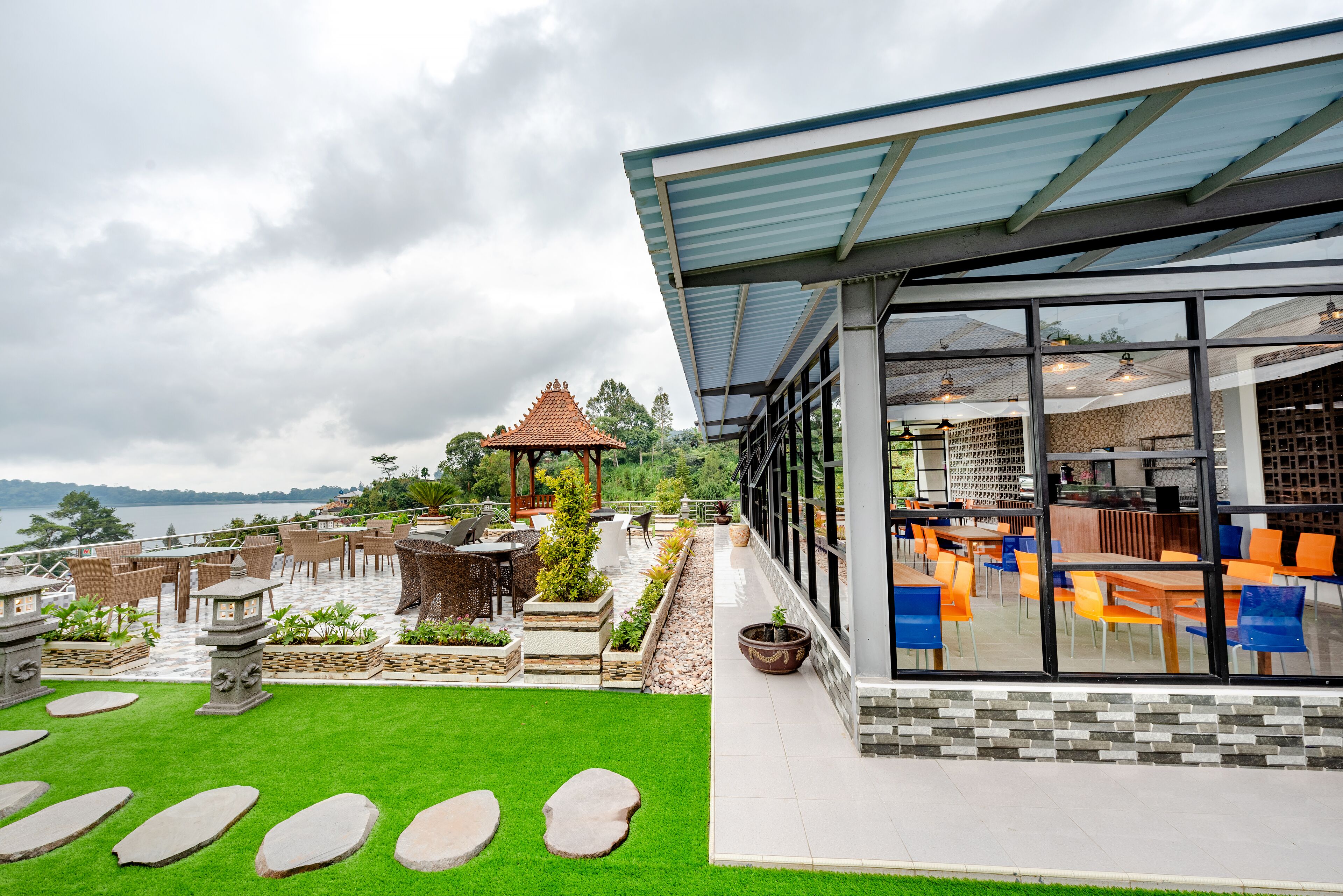 Una terraza en la azotea con mobiliario exterior, un pabellón y vistas al agua.