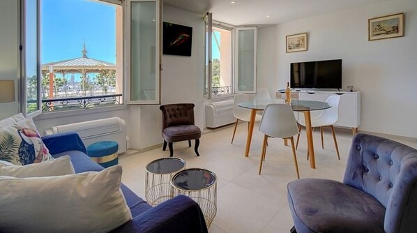 Una sala moderna con sofá, sillón, mesa de comedor y sillas.