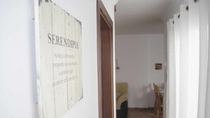 Käytävällä on maalaishenkinen kyltti, jossa lukee ”SERENDIPIA”, ja ruokailutilassa on pöytä ja tuolit.