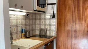 A compact kitchen with a microwave, a sink, and a wooden countertop. - Equipped studio with parking in Balaruc-les-Bains (Balaruc-les-Bains)
