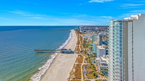 A coastal cityscape with a beach, a pier, and high-rise buildings. - Atlantica 803 (Myrtle Beach)
