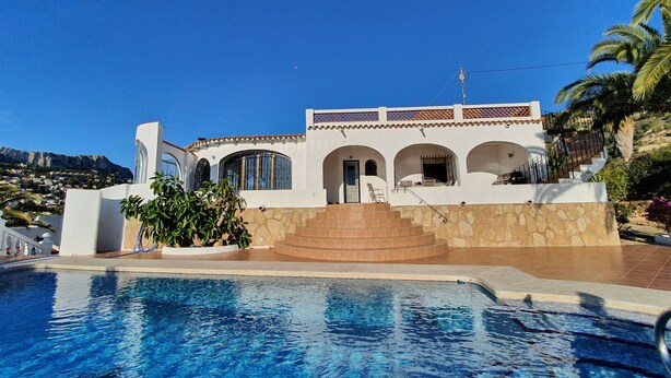 Villa blanca amb piscina, escales de pedra i finestres d'arc.