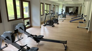 A gym with cardio machines, mirrors, and a view of the outside. - 4-person apartment, at the foot of the slopes, Ariège (Ustou)