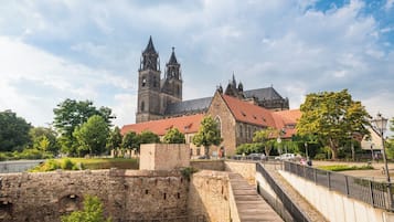 Ein historisches Gebäude mit einem markanten Turm und einem Gebäude mit rotem Dach.