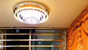 Un interior de varios niveles con una escalera, un muro decorativo con una escultura de elefante y una lámpara moderna.