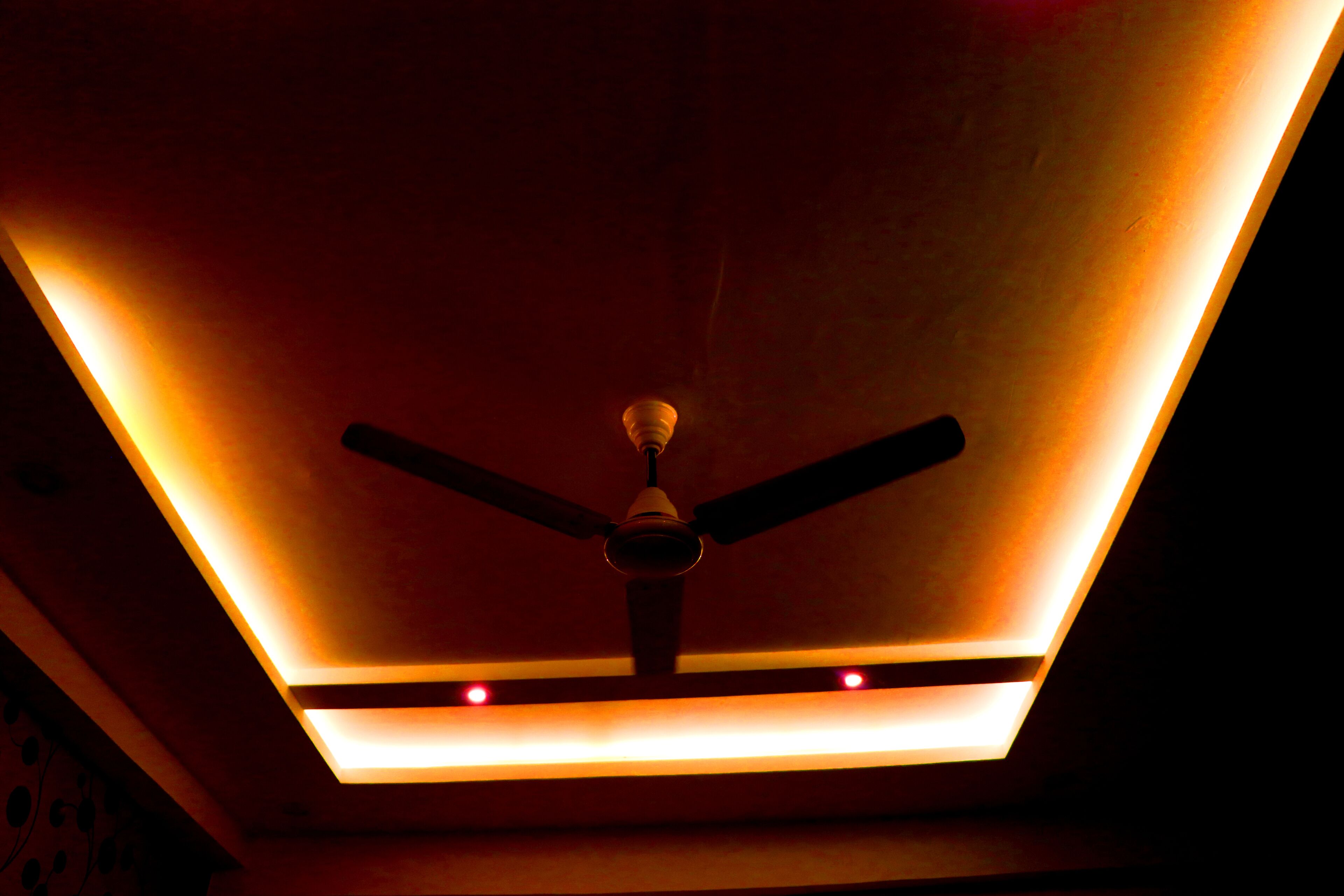 Een plafond met een ventilator en inbouwverlichting.
