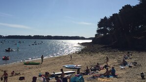 A beach with people sunbathing and swimming, boats on the water, and a forested cliff. - 100m from the beach, house for 7, seaview (Baden)
