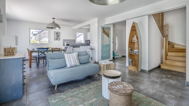A modern living room with a sofa, a dining area, a kitchen, and a staircase. - 100m from the beach, house for 7, seaview (Baden)
