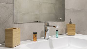 Un bagno moderno con uno specchio grande, un lavandino bianco e due contenitori in legno.