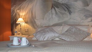 A hotel room with a bed, a nightstand with a lamp, a water bottle, and a tray with a mug and a cup. - Le Clos Margot (Blancs-Coteaux)