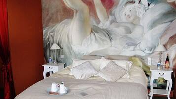 Une chambre à coucher avec un grand lit, deux tables de chevet, une commode, un rideau rouge et un tableau au mur.
