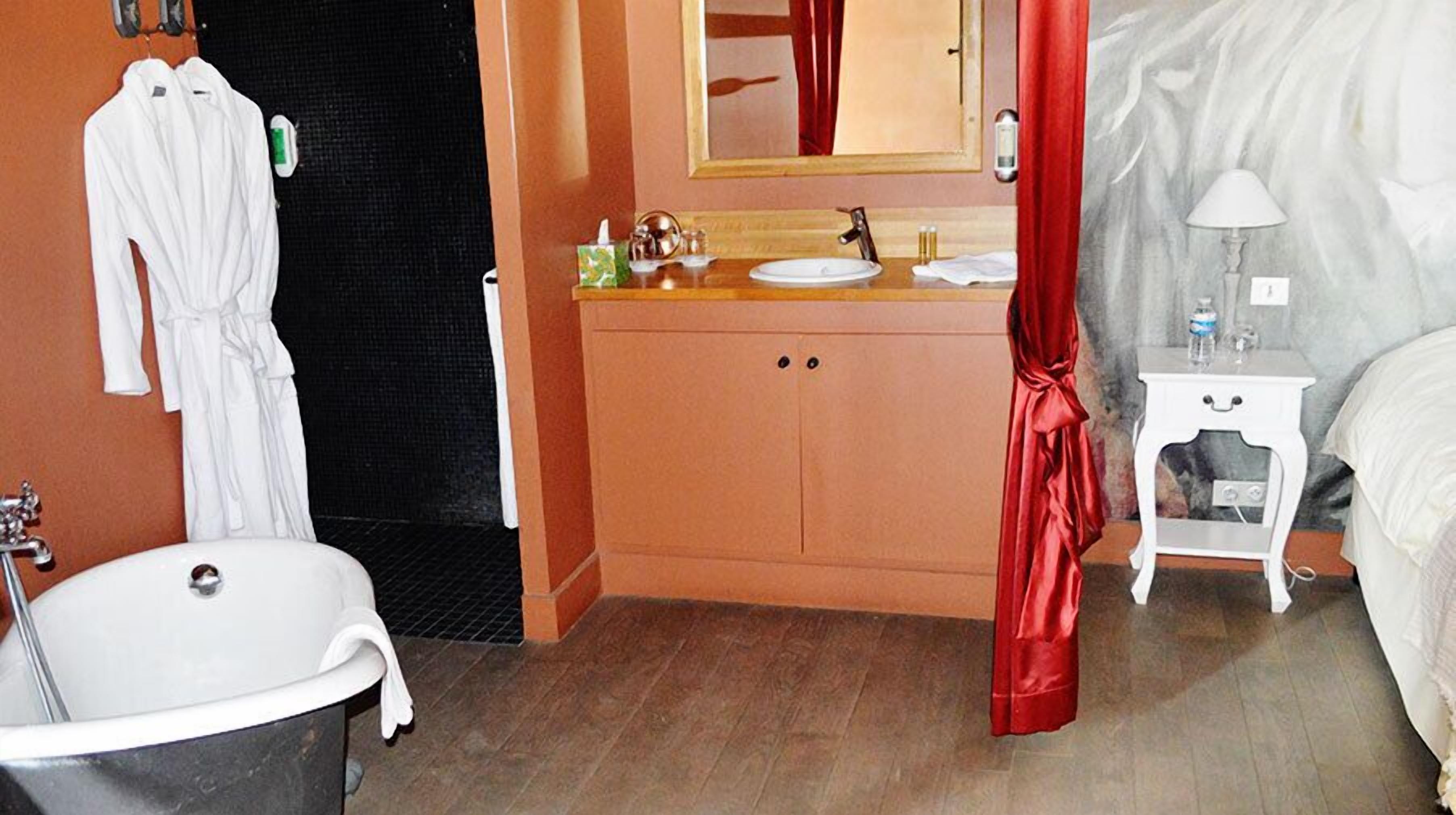 Een badkamer met een bad, wastafel en spiegel.