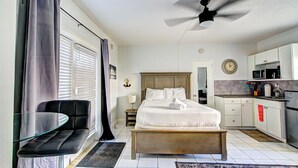 Une chambre comprenant un lit, une table de chevet et un petit coin salon avec une table en verre.