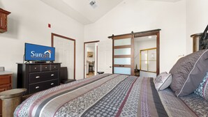 A bedroom with a bed, a dresser, a television, and a sliding door. - Reflection Retreat - A quiet Oasis by Table Rock Lake. Come and relax! (Hollister)