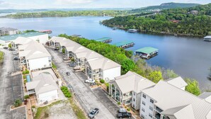 A waterfront hotel with multiple buildings, a parking lot, and a lake with boats. - Reflection Retreat - A quiet Oasis by Table Rock Lake. Come and relax! (Hollister)