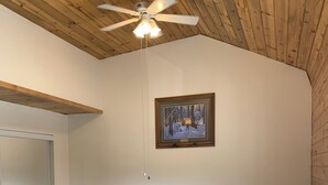 A dining area with a wooden table and blue chairs, a ceiling fan, and a framed picture on the wall. - Lake Front Rental/Downtown Grand Lake
Apt 3 The Falcon (Grand Lake)
