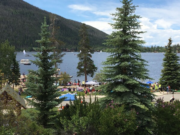 Une zone au bord du lac avec un quai, des bateaux et des gens.