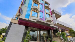 Un edificio de varios pisos con un diseño arquitectónico moderno, con balcones y ventanas amplias.