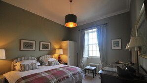A bedroom with a bed, bedside tables, a desk, a chair, and a window with curtains. - Carnell Private Apartment (Hurllford)