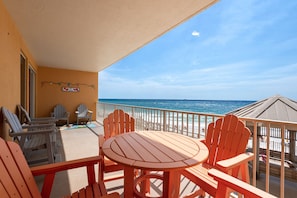 Enjoy the ocean view from this balcony with Adirondack chairs and a table.
