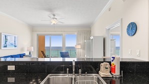 Eine moderne Küche mit einer Spüle, einem Deckenventilator und Blick auf den Balkon.