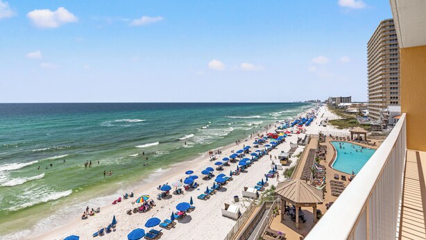 Ein Strandresort mit Pool, Sonnenschirmen und Blick auf den Ozean.