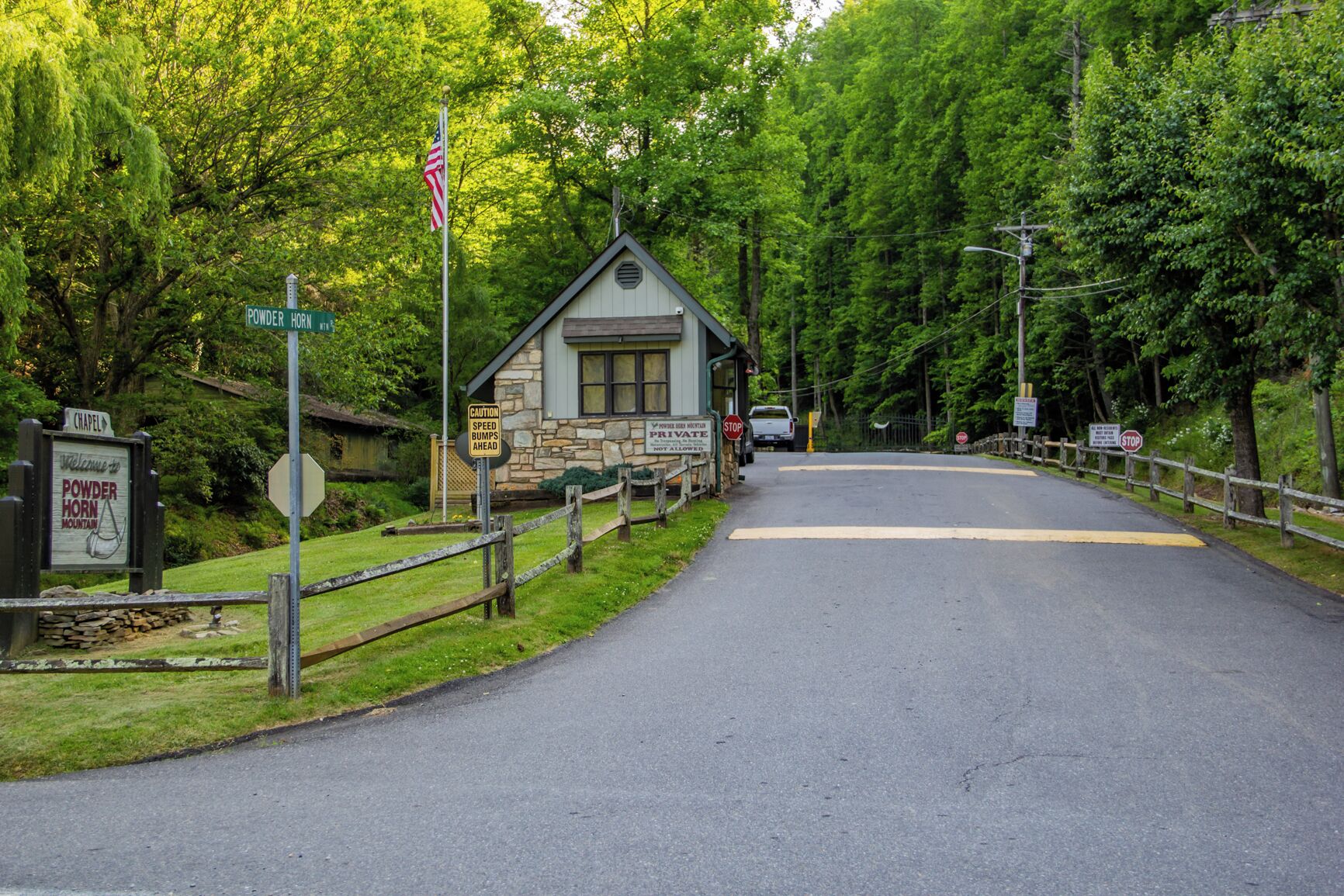 A road leading to a stone building with a sign indicating 'Powder Horn Mountain'.