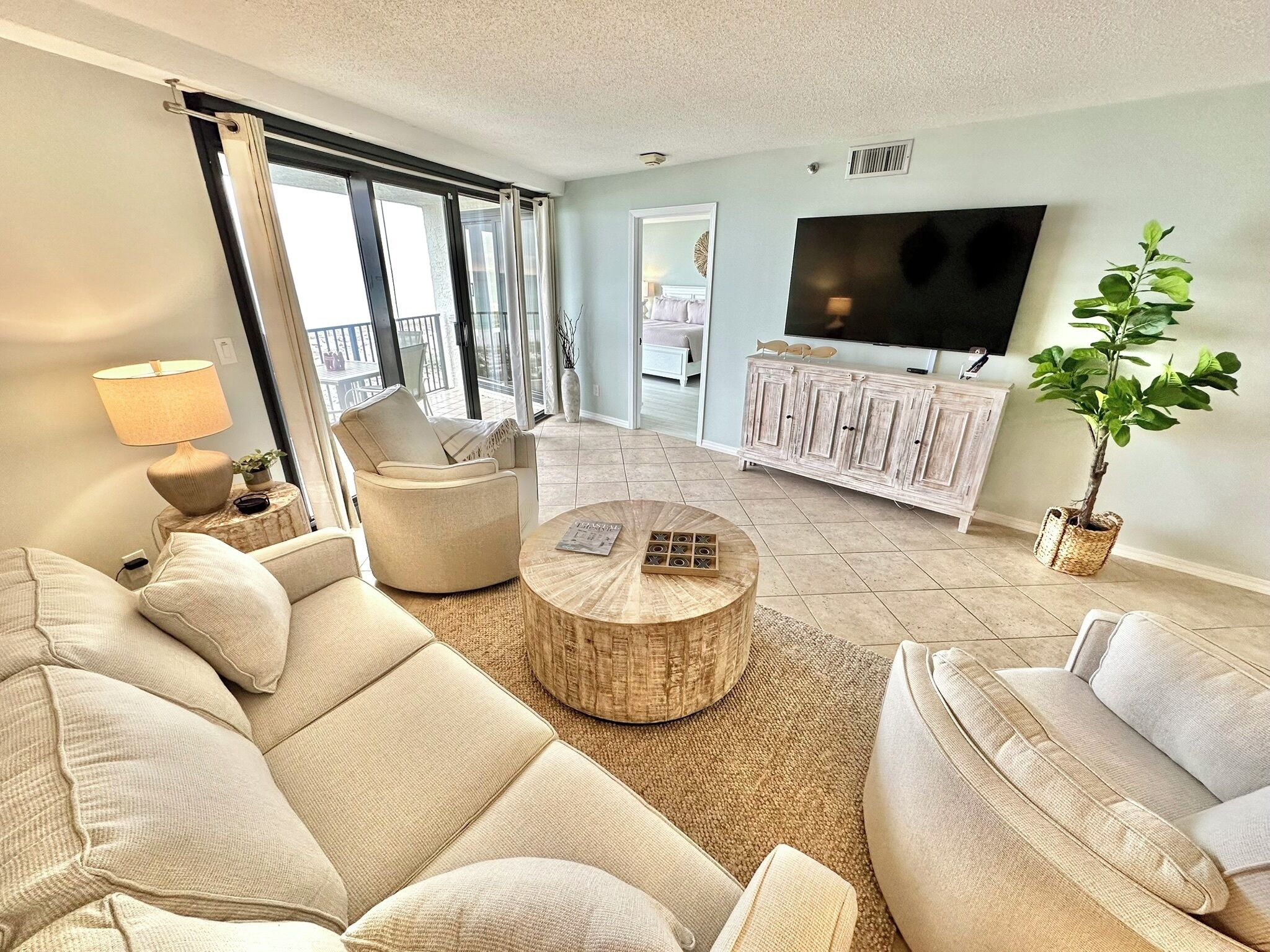 Una sala de estar moderna con un sofá, un sillón, una mesa de centro y una televisión.