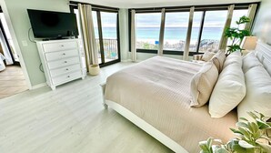 A bedroom with a large bed, a TV, and a balcony with a view of the sea. - Stunning Beachfront Unit Great Views Golf Cart4045 (Miramar Beach)