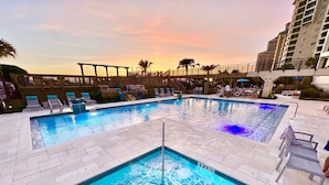 A pool area with multiple pools, lounge chairs, and a wooden pergola. - Stunning Beachfront Unit Great Views Golf Cart4045 (Miramar Beach)