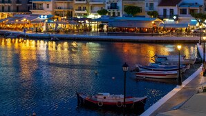 A waterfront area with boats docked, a promenade, and buildings with outdoor seating. - Modern hilltop villa with pool near Agios Nikolaos (Vathi)