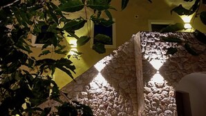 Eine Steinstruktur, im Hintergrund ein gelbes Gebäude.