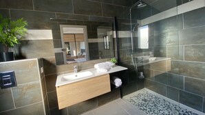 A modern bathroom with a glass-enclosed shower, a wooden vanity, and a large mirror. - Residence Casa U Fornu APT3 (Ile Rousse)