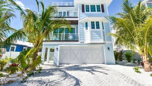A two-story house with a white exterior, a garage, and a driveway. - Ocean Breeze (Bradenton Beach)
