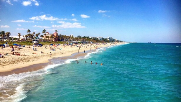 A beach with clear blue water, sandy shore, and buildings in the background. - You will Love this Charming Townhouse in West Palm Beach, West Palm Beach Villa 1862 (West Palm Beach)