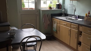 Une cuisine avec une table et des chaises, une fenêtre donnant sur un beau paysage et des placards en bois.