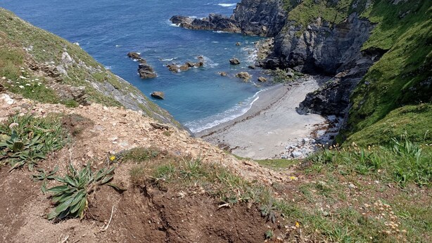 Un paysage côtier avec des falaises, une plage et l’océan.