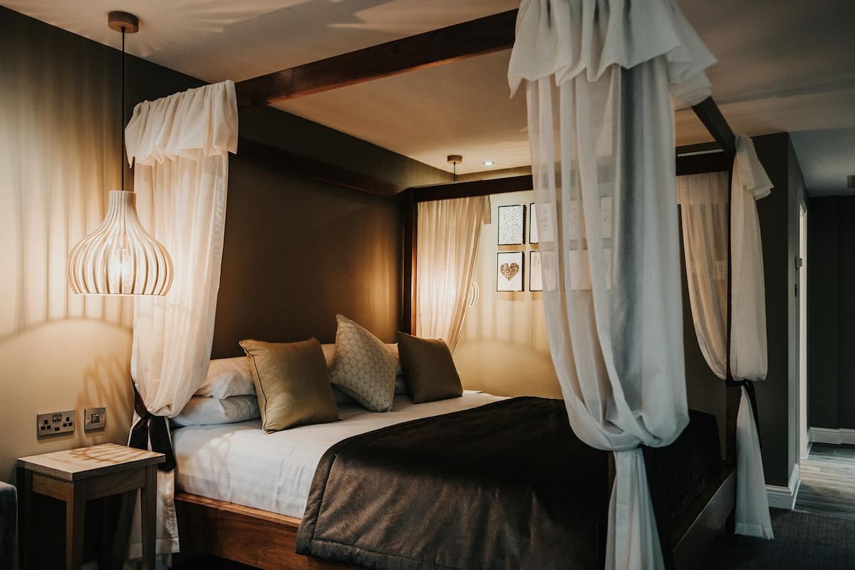 Une chambre à coucher avec un lit à baldaquin, des lampes de chevet et une table de chevet.