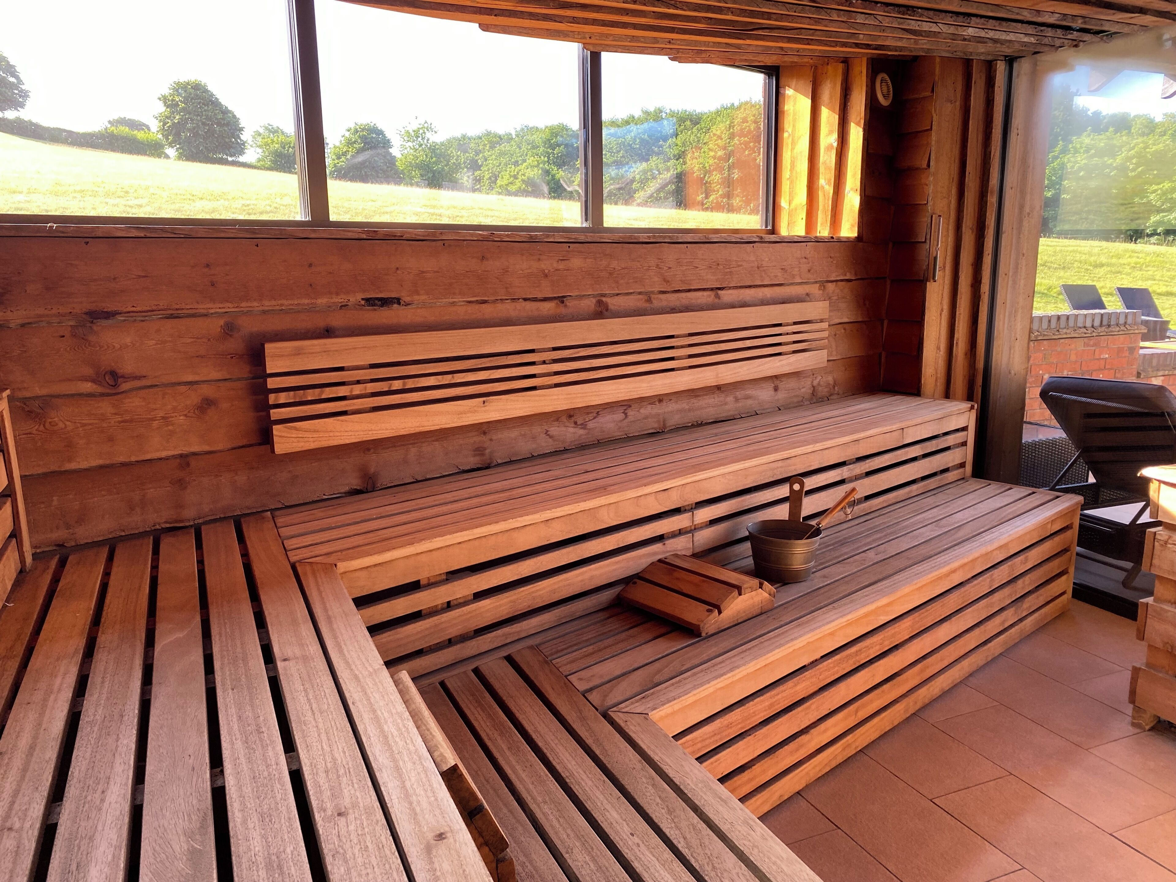 A wooden bench seating area with a view of a grassy field.