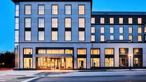 Un hotel moderno con fachada plana, ventanas amplias y una entrada destacada.