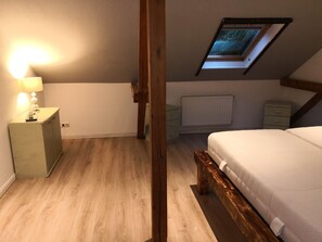 Cozy retreat with a sloped ceiling, skylight, and comfortable bed.