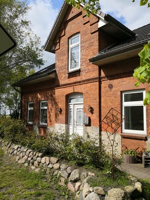 Stunning two-story house with a central entrance, flanked by windows and a decorative metal feature.