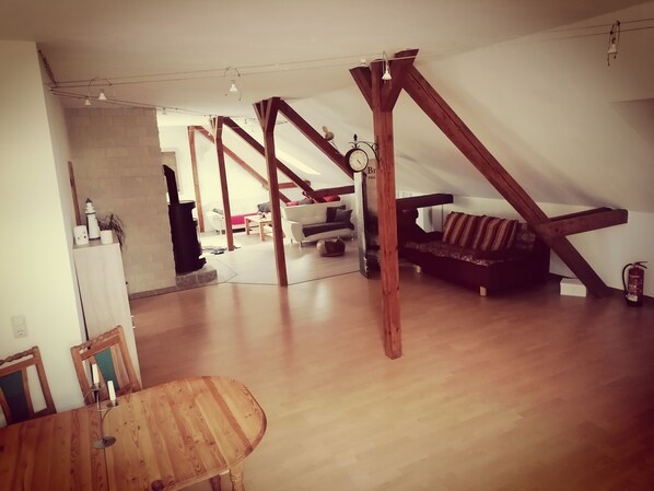 Cozy loft-style living area with a dining table, sofa, and fireplace.