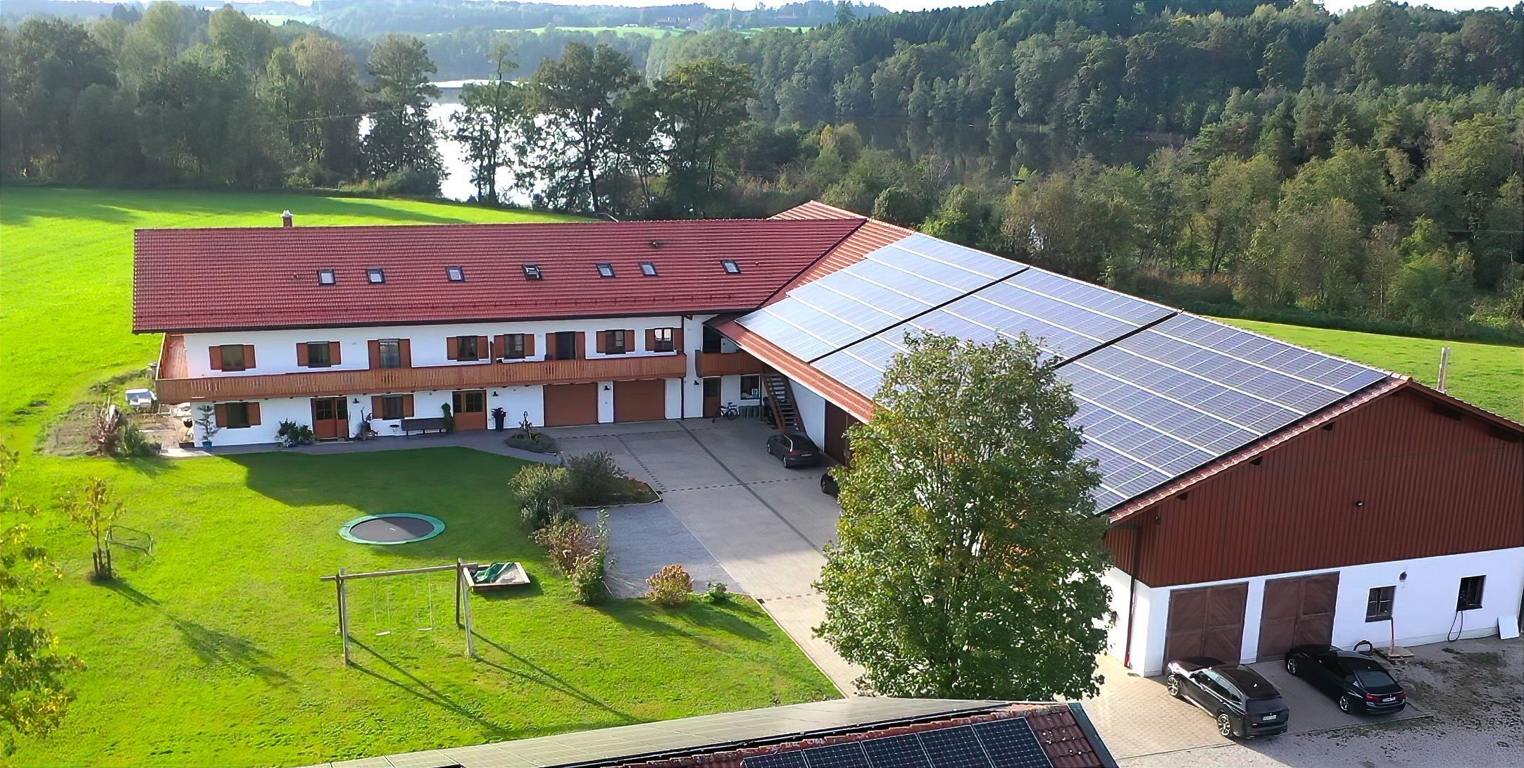 A large building with multiple rooms, a covered parking area, and solar panels on the roof.