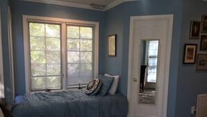 Une chambre à coucher avec un lit, une porte et une fenêtre.