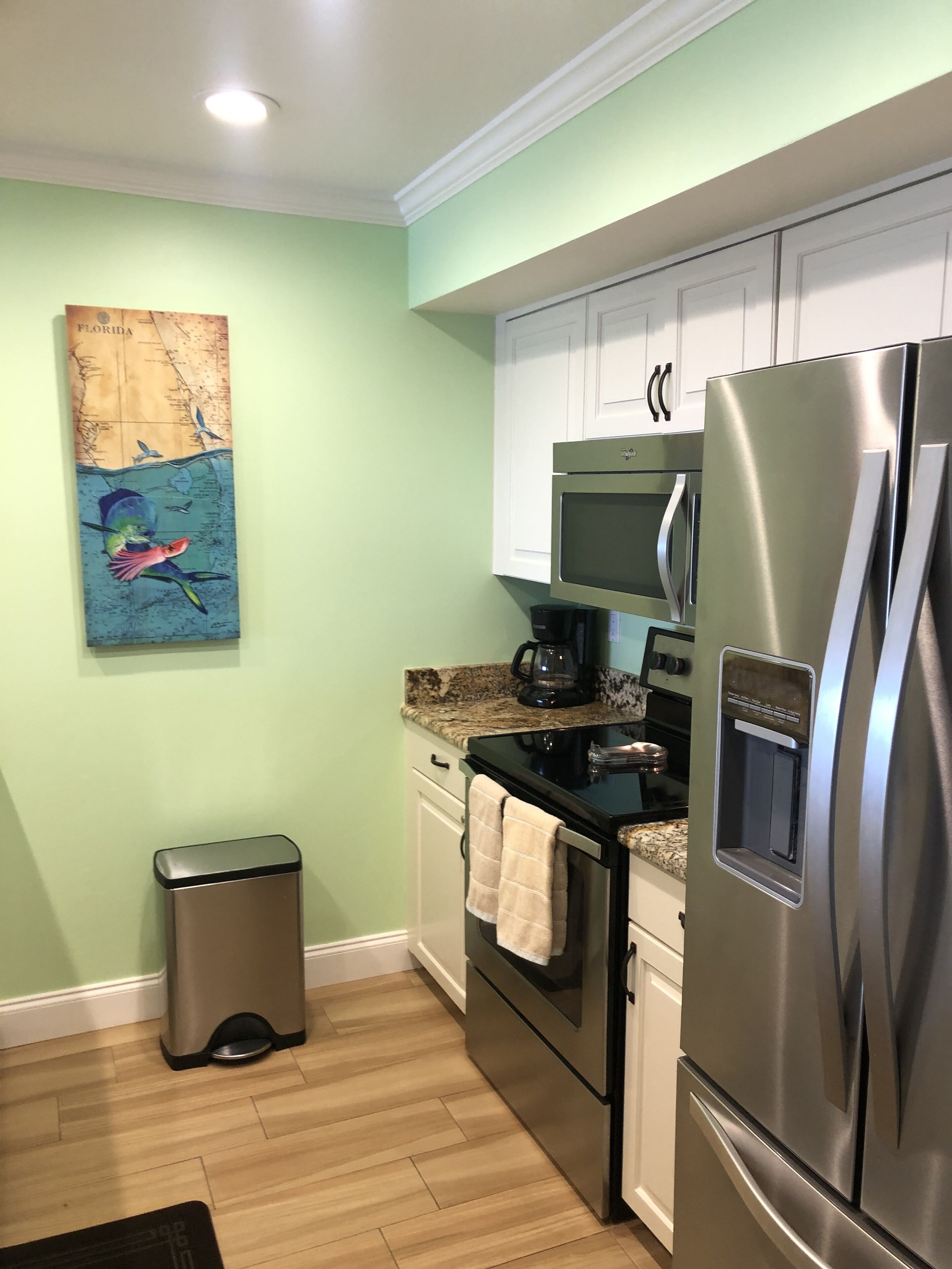 A kitchen with a stainless steel refrigerator, a microwave, and a coffee maker on the countertop.