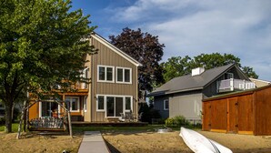 A residential area with a wooden dock leading to a house with a balcony and a garage. - Relaxing Oxford Retreat (Oxford)