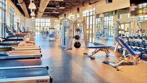 A gym with treadmills, weight machines, and dumbbells. - South-Facing Pool & Spa • No Rear Neighbors • Game Room • Near Disney (Kissimmee)