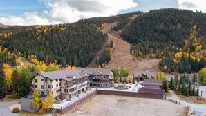 Eine Lodge mit mehreren Gebäuden, einem großen Parkplatz und einer Bergkulisse.