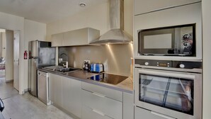 A modern kitchen with stainless steel appliances, a built-in oven, and a microwave. - LE RICHELIEU - Magnifique duplex avec une vue Incroyable (Bordeaux)
